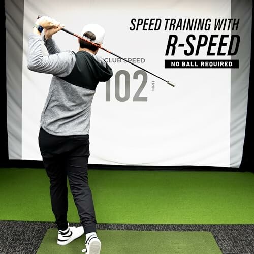 Person practicing golf swing with speed training equipment indoors.